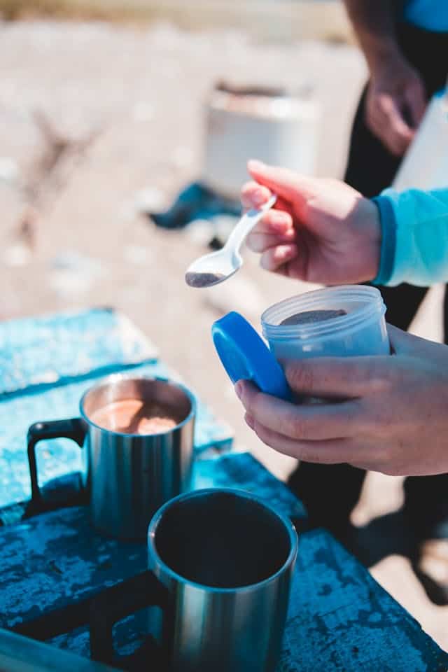 Anonymous tourists preparing instant coffee during trip